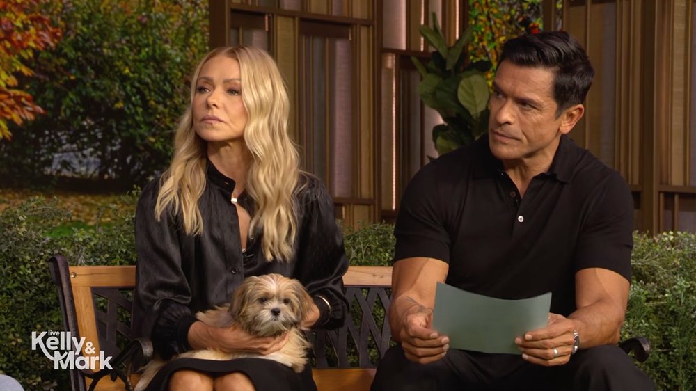 Kelly Ripa and Mark Consuelos sit with a dog on the set of their show, "Live with Kelly and Mark"