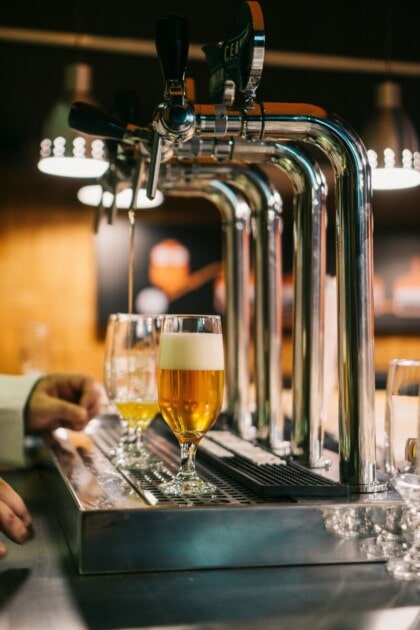 A bartender pours a pint of beer.