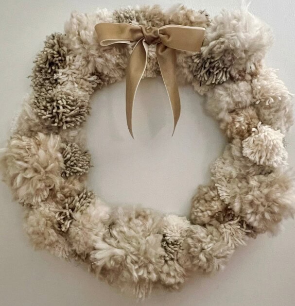 A wreath made out of yarn pom poms
