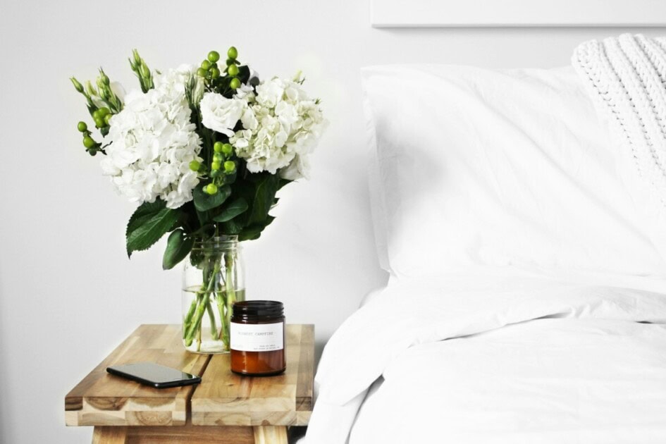 Bedside table with florals and a candle