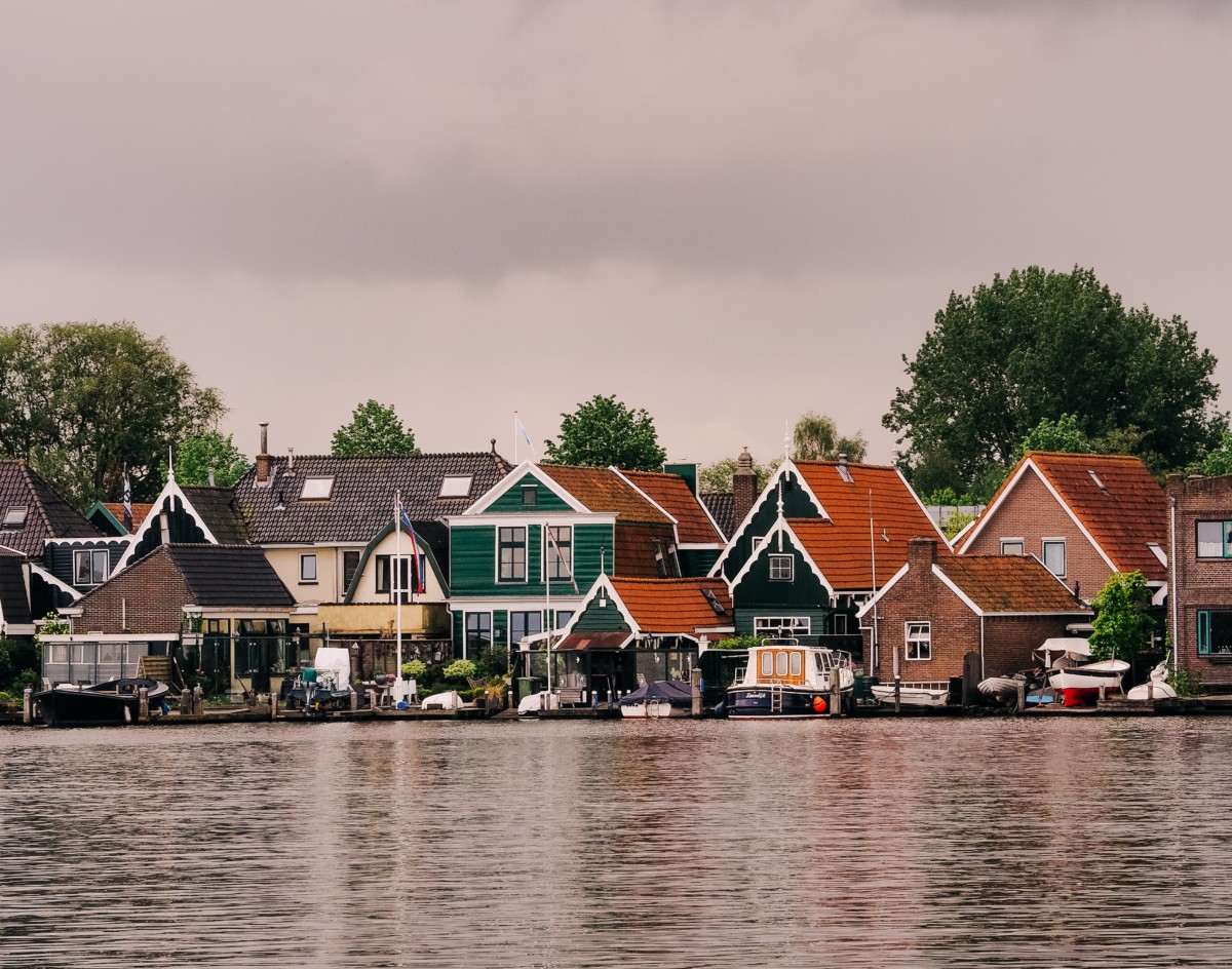 homes on a lake with boats on the dock next to the homes