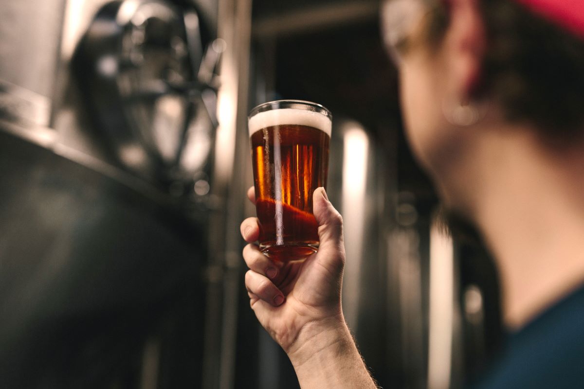 person with glass of beer