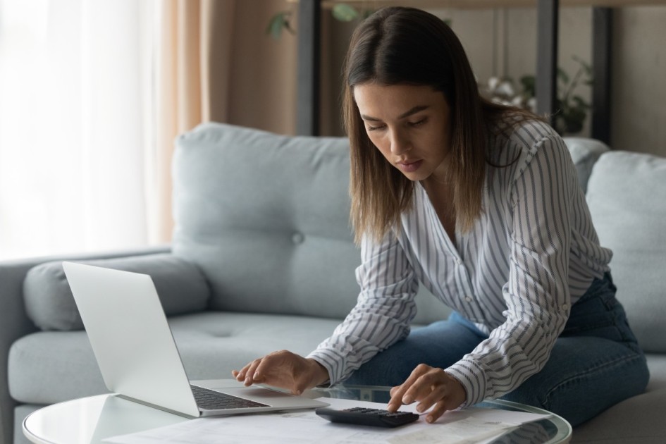 A woman using her laptop and calculator.