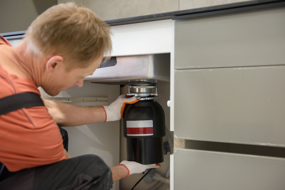 plumber installing new garbage disposal