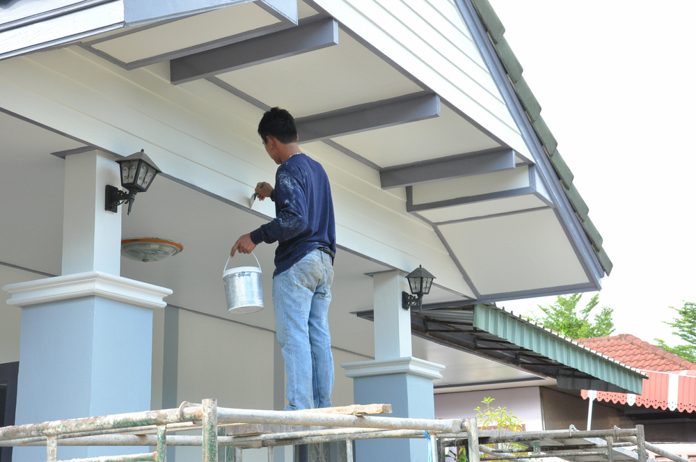 a professional painter, painting the exterior of a house