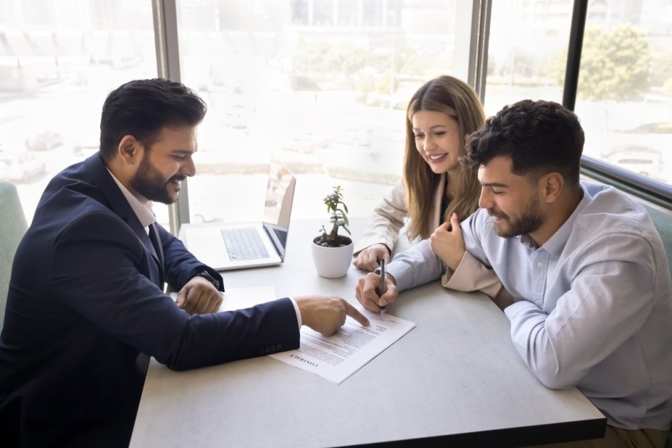A couple with an agent looking over first-time home buyer benefits.
