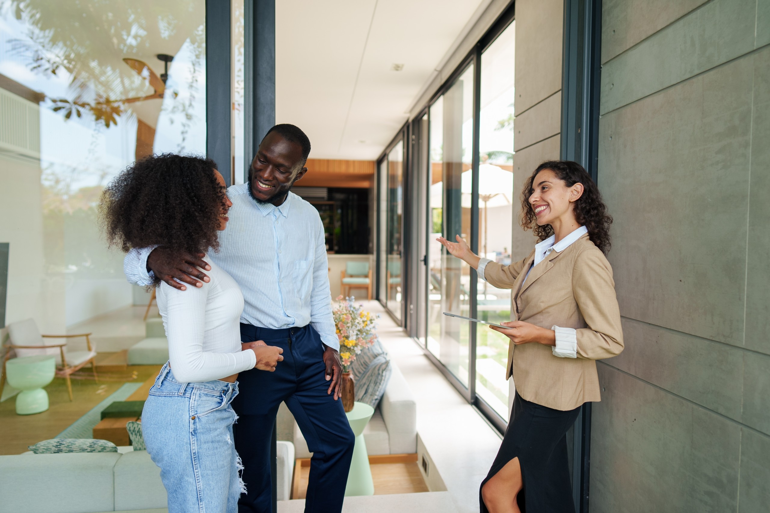 People attending a house viewing with a realtor inside a bright room.