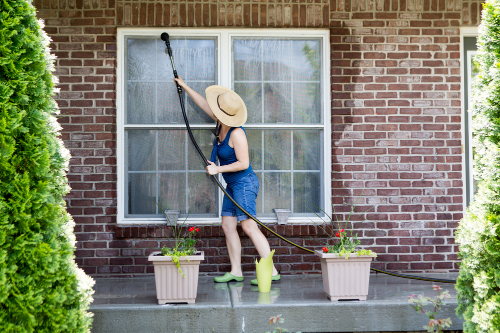 woman outside cleaning her windows