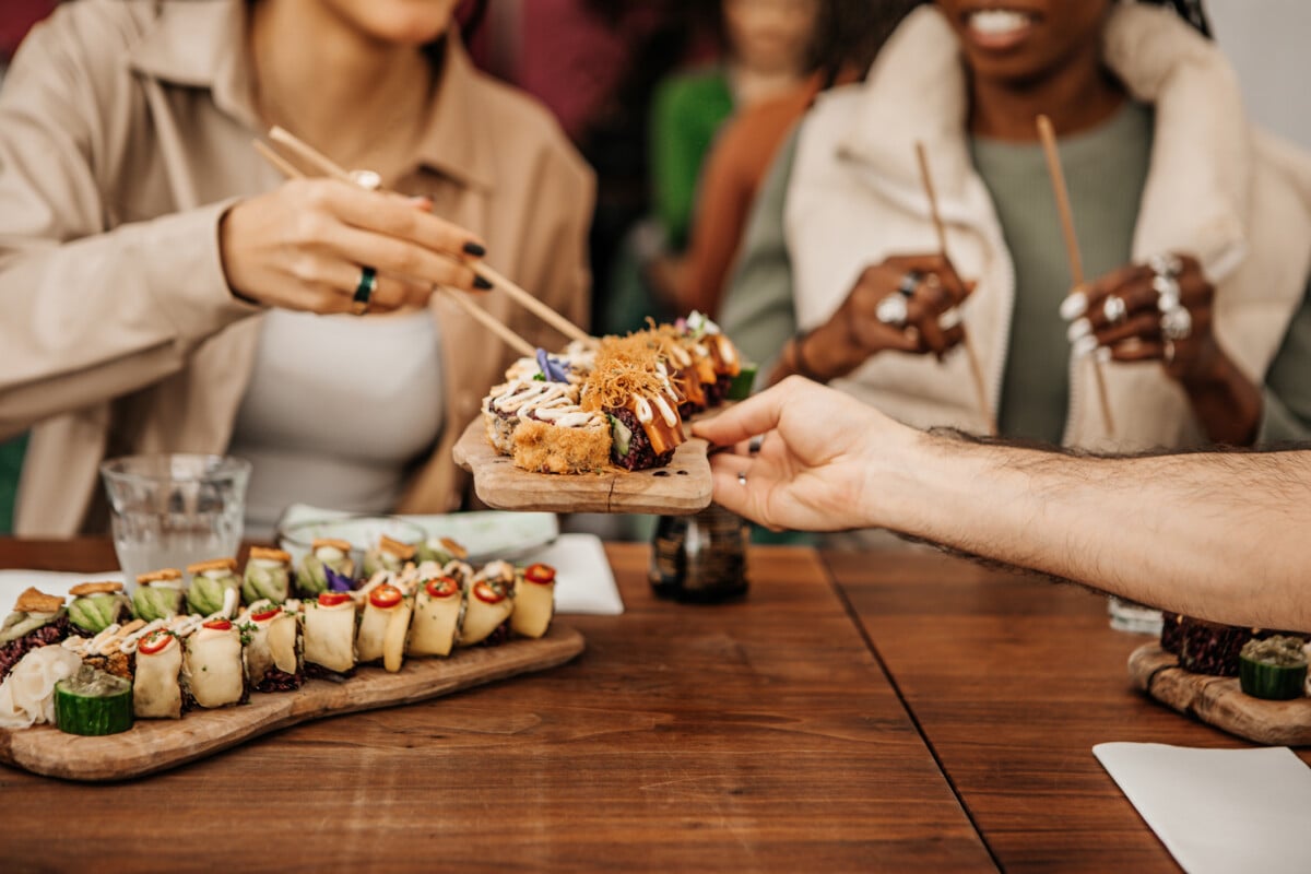 Friends enjoying sharing Vegan Sushi in a local restaurant