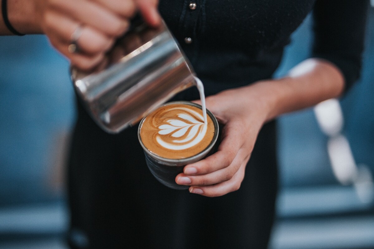 barista making latte art with foam