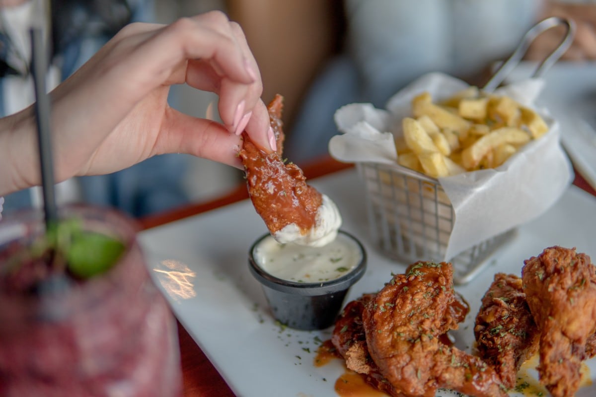 chicken wings fries and drinks on a table